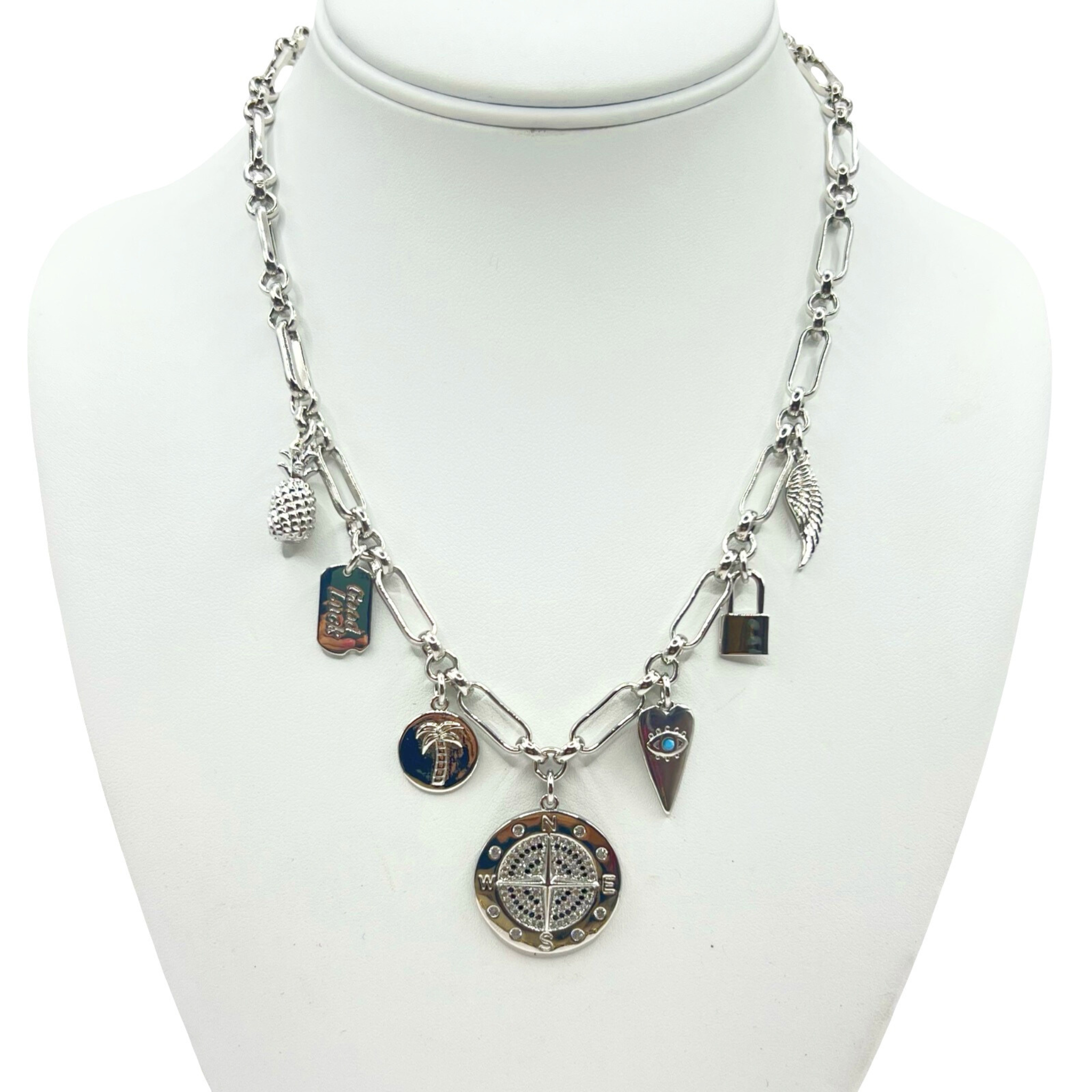 Silver thick link chain necklace with mixed charms including compass, evil eye heart, palm tree, and padlock by HOLST+LEE